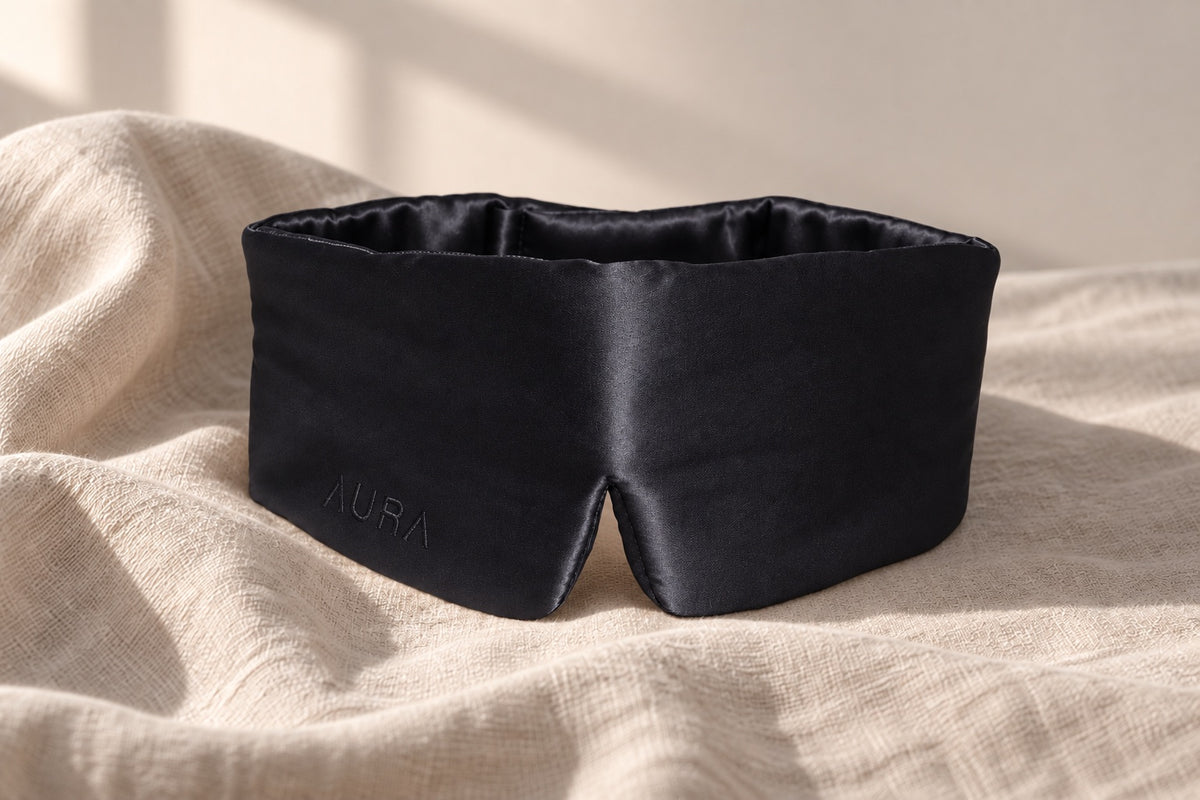 Aura silk sleep mask in Black — on linen