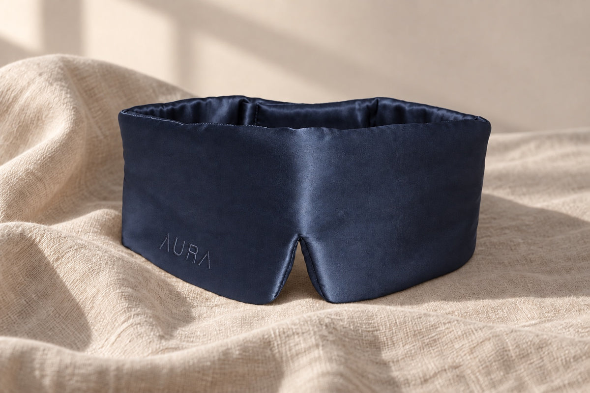 Aura silk sleep mask in Navy — on linen